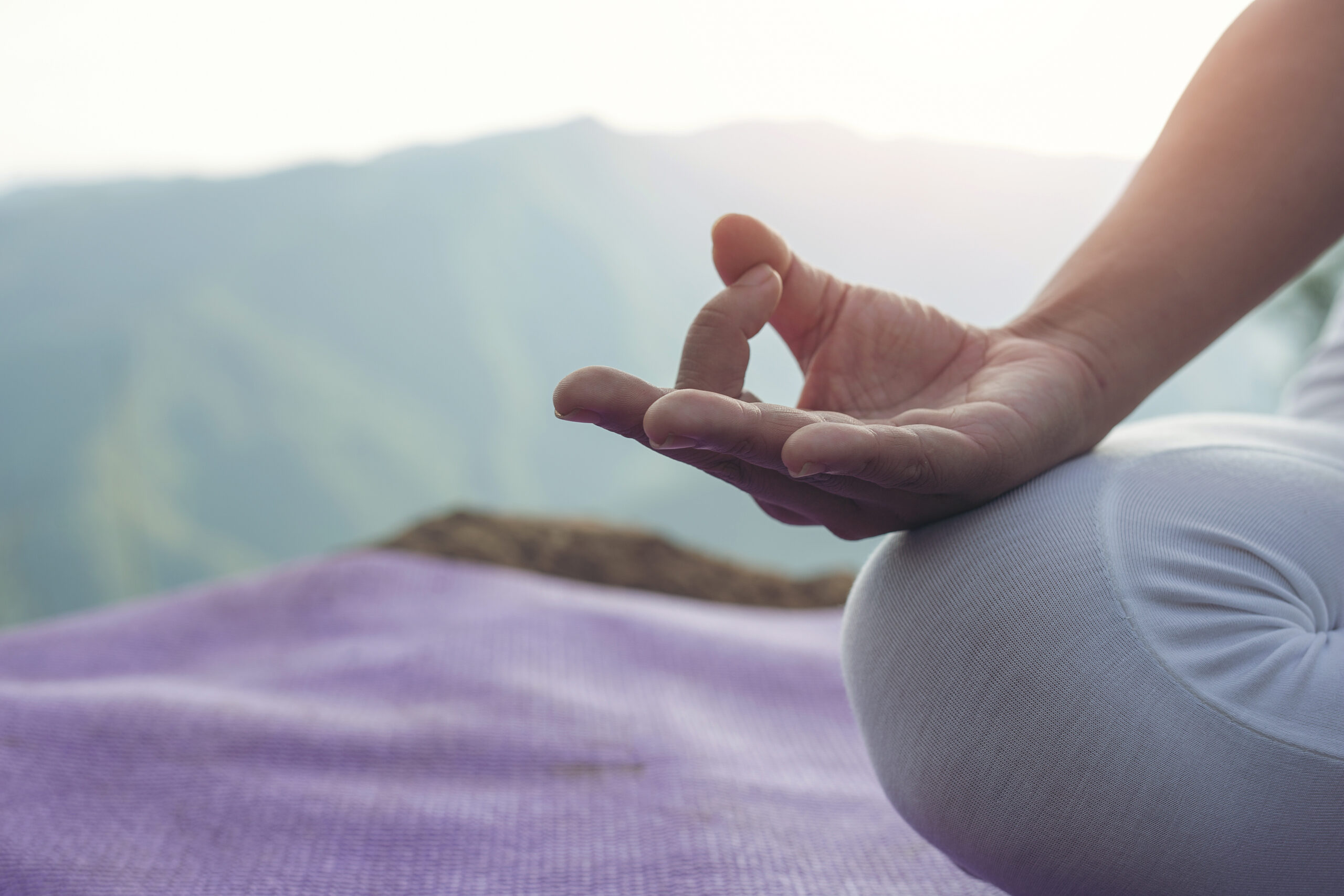 Beautiful young woman meditating and exercising on top of him.
